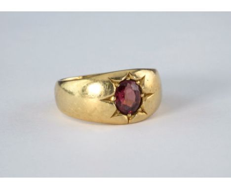 An antique 18ct yellow gold and garnet ring, the single oval cut star set in the broad shank, ring size M½.