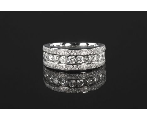 An 18ct white gold and diamond three row half eternity ring, the central row of eleven channel set brilliant cut diamonds wit