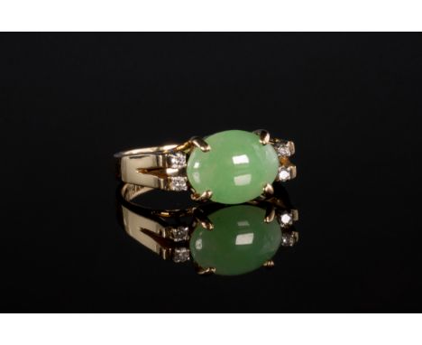 A 15ct yellow gold, jade and diamond ring, the oval cabachon pale green jade, 11 x 8.5mm., claw set between split shoulders s