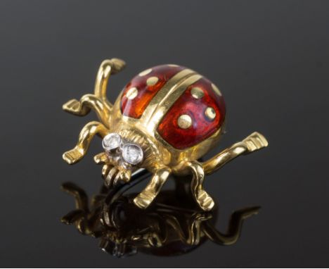 An 18ct gold and enamel ladybird brooch, the eyes set with tiny diamonds, 15mm. long.