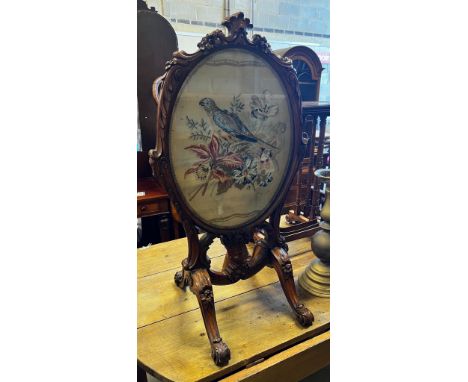 A Victorian carved walnut fire screen with needlework parrot banner, width 56cm, height 99cm *Please note the sale commences 