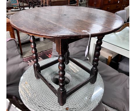 A circular oak bobbin legged table, diameter 73cm, height 61cm *Please note the sale commences at 9am.