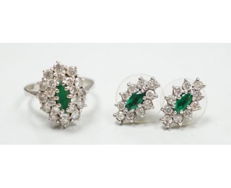 A modern 18ct white gold, emerald and diamond set oval cluster ring, size K/L and a pair of matching earrings, gross weight 7