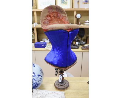 An early 20th century 'Prima Donna' red velvet corset mannequin on turned stand with a contemporary blue satin corset, manneq