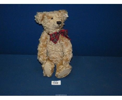 A jointed Steiff Teddy bear with squeaker and tartan bow, 12 1/2'' tall.