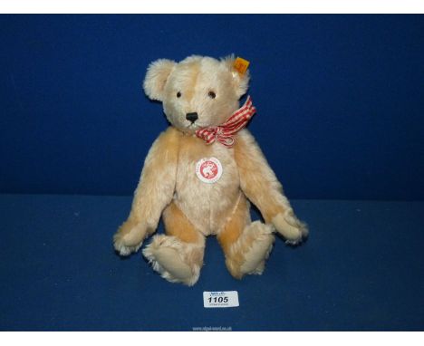 A Steiff jointed Teddy bear with red and white ribbon.