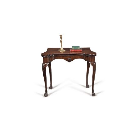 A George II Irish mahogany folding card table, circa 1750, the top with rounded corners enclosing a baize playing surface and