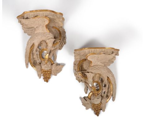 A pair of carved wood, painted and parcel gilt wall brackets, in George III style, 19th century and later, each serpentine sh