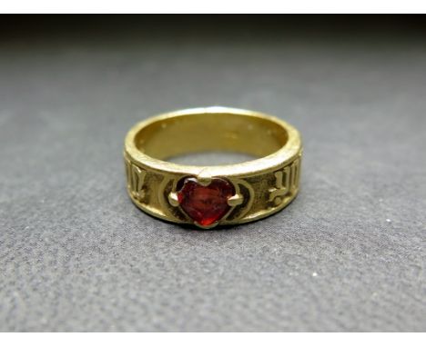 A 14ct gold garnet band ring - The heart-shape garnet inset to the decorative band - Hallmarked Sheffield - Ring size K 1/2 -