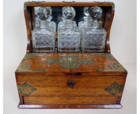 An oak three decanter Tantalus with key - 33cm x 33cm x 27cm 