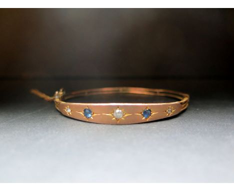 An early 20th century gold sapphire and diamond hinged bangle - Tests as higher that 9ct gold - Weight approx 6.9gms
Conditio