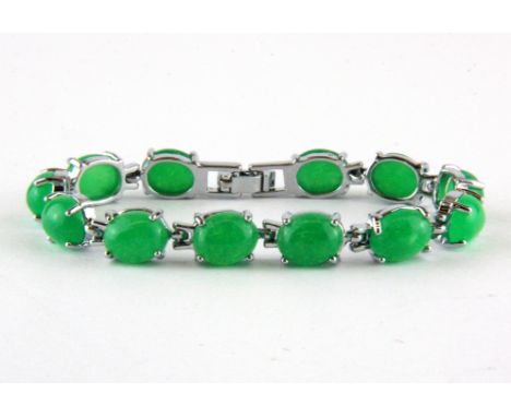 A white metal and jade bracelet.