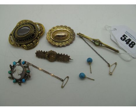 A XIX Century Mourning Brooch, of shaped design with central oval glazed locket panel encasing hair work, highlighted in blac