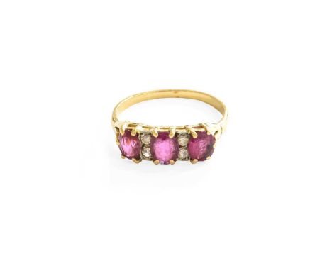 A Ruby and Diamond Ring, three oval cut rubies spaced by pairs of eight-cut diamonds, in yellow claw settings, to a tapered s