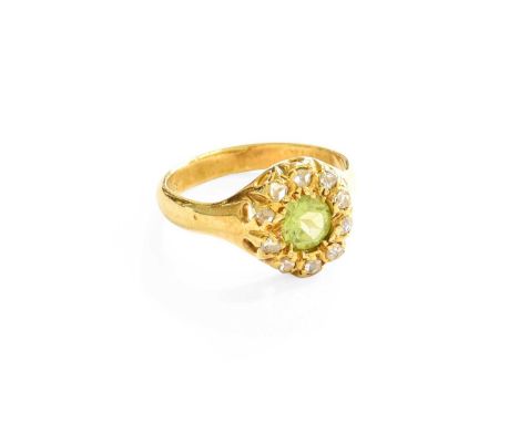 A Peridot and Diamond Cluster Ring, the round cut peridot within a border of old cut diamonds, in yellow claw settings, to a 