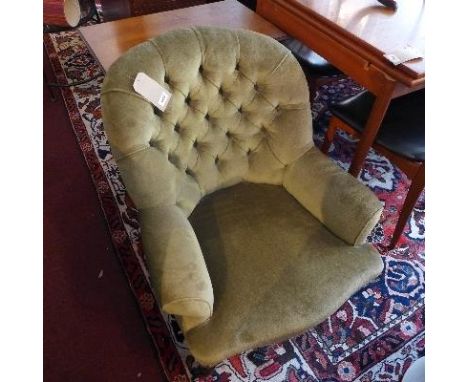 A Victorian button back armchair, with green velour upholstery, raised on turned legs and castors 