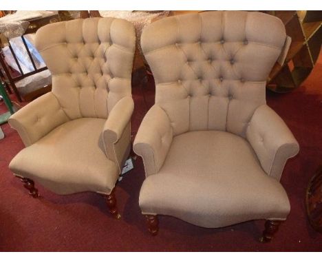 A pair of Victorian style armchairs, with button back linen upholstery, raised on turned legs and castors 