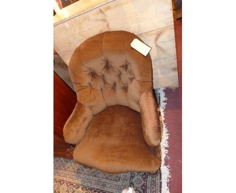 A Victorian spoon back armchair, with brown velour button back upholstery, raised on turned legs and castors 