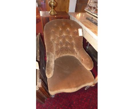 A Victorian spoon back armchair, with brown velour button back upholstery, raised on turned legs and castors 