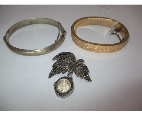 Silver and Marcasite Nivada Brooch Watch, a Silver Bangle and a Gold Plated Bangle 