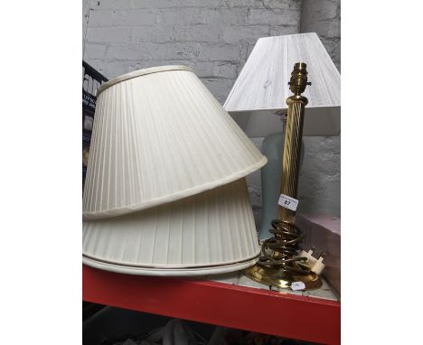A brass lamp and a pottery lamp with additional shades. 