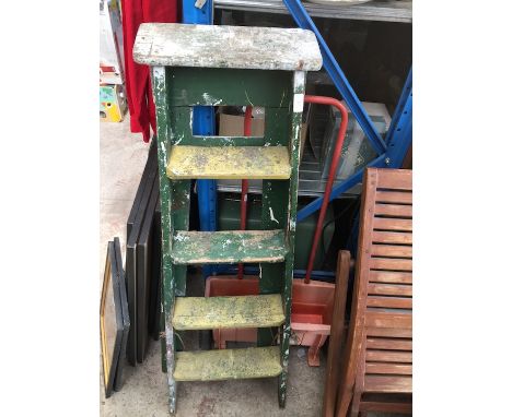 A small green pair of wooden step ladders 