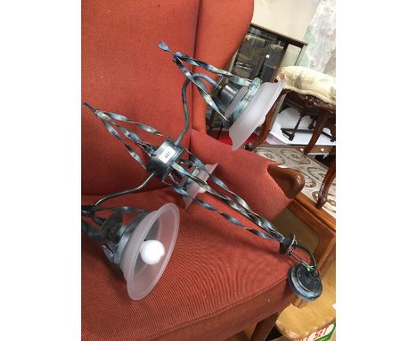 A wrought metal ceiling light fitting with glass shades 