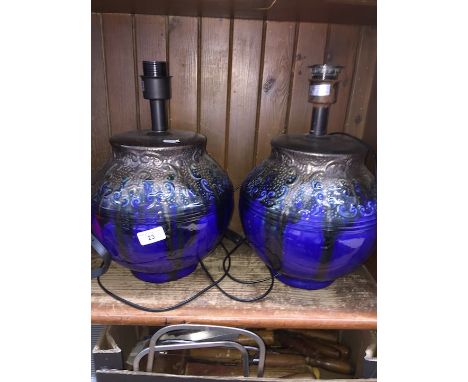 A pair of blue and black ceramic lamps with shades.