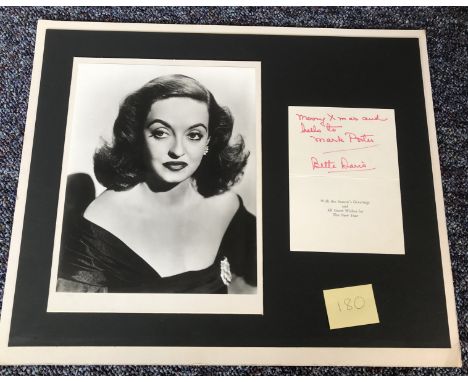 Bette Davis signed Christmas card, with a personal dedication, mounted with a black and white 10x8 photo on a 18x15 mounted f