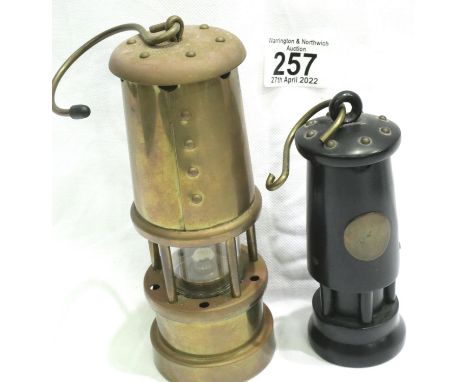 Small brass miners lamp with Welsh dragon plate, H: 17 cm and a carved ebony example. P&amp;P Group 2 (£18+VAT for the first 