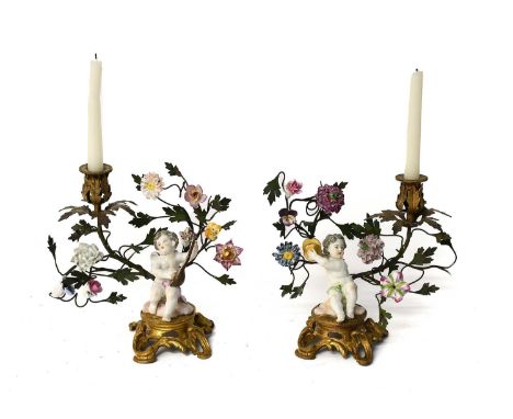 A Pair of Continental Porcelain and Gilt Metal-Mounted Figural Candlesticks, 19th century, with porcelain flowers and each su