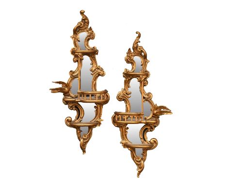 A Pair of Giltwood and Gesso Wall Mirrors, late 19th/early 20th century, the plain mirror plates framed by C scrolls and flow