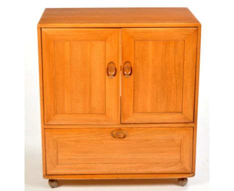 Ercol: a light stained elm television cabinet, two cupboard doors above a fall-flap below, 84cms (33in.) wide.