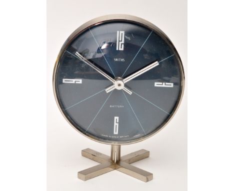 A 1970's Smiths battery operated table clock, the blue circular dial with quarter arabic numerals, on a chromed cross form st
