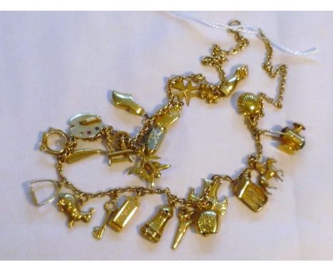 9ct gold marked charm necklace with twenty three charms including spinning wheel, artist palette, harmonica, handcuffs and co