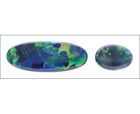 Two unmounted black opals, the first elongated oval opal with colour play of  blues and greens, the second smaller stone with