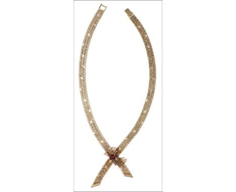 A 9ct gold necklace, 1977, the textured brick-link necklace with a crossover front and applied scroll with three circular-cut