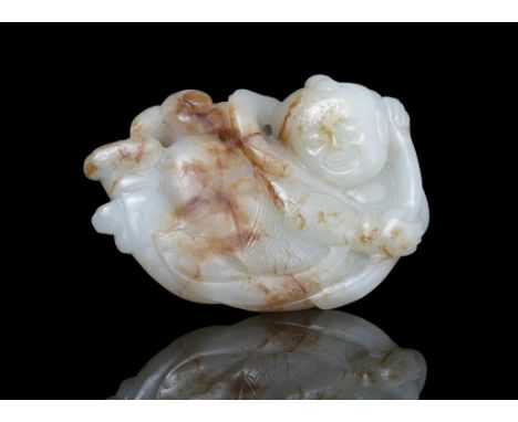 A WHITE AND RUSSET JADE CARVING OF A BOY WITH A LOTUS SPRIG China, Attributed to Ming Dynasty, 16th-17th century Skilfully re