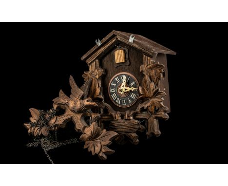 Vintage Carved Wood Cuckoo Clock with bird and leaf decoration to pitched top, and leaf and nest carving surrounding the cloc