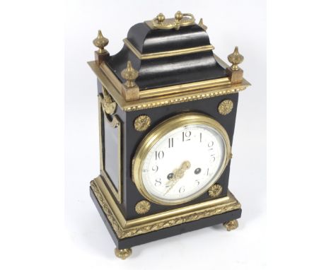 An early 20th century ebonised and gilt ormolu decorated bracket clock. With upper carrying handle and four corner finials ab