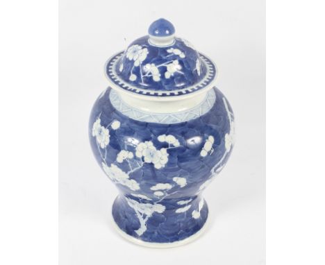 A 19th century Chinese blue and white bulbous jar and cover. Decorated with prunus, six character Kangxi mark to the base. H3