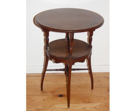 An Edwardian circular occasional table, the crossbanded top above an undertier with shaped apron, on turned legs joined by an