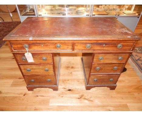 An early 19th Century mahogany kneehole desk with moulded leather inset top over two frieze drawers and six graduated opposin