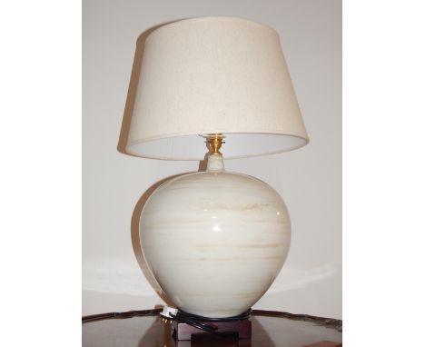 A Modern porcelain table lamp, cream ground of bulbous form, raised on carved wooden stand. H. 49cm