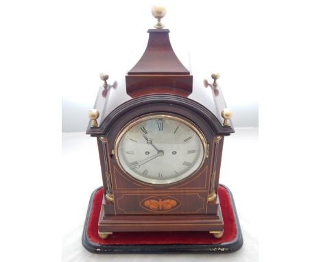 A late 19th/early 20th century mahognay mantel clock, the top with brass ball finials above a silvered dial set out in Roman 