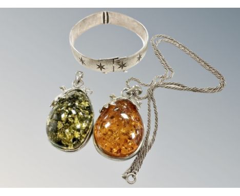 Two Baltic amber pendants, one on silver chain, together with a silver bangle (misshapen) CONDITION REPORT: Bangle weighs 36.