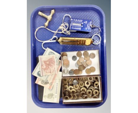 A tray containing pocket balance scales, foreign bank notes and coins. 