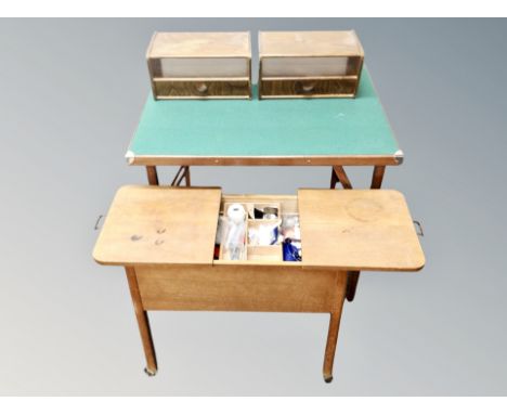 A mid century sewing box with contents together with a pair of wall shelves and a folding baize topped card table 