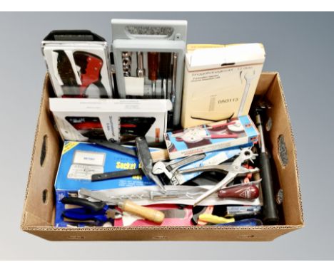 A box containing boxed and unboxed hand tools including screwdrivers, hammers, wire cutters. 