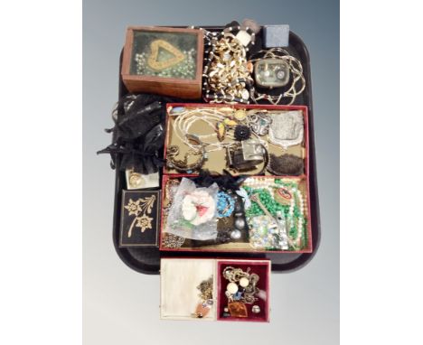 A tray containing assorted costume jewelry, metal mesh purses, faux pearls, locket on chain etc. 